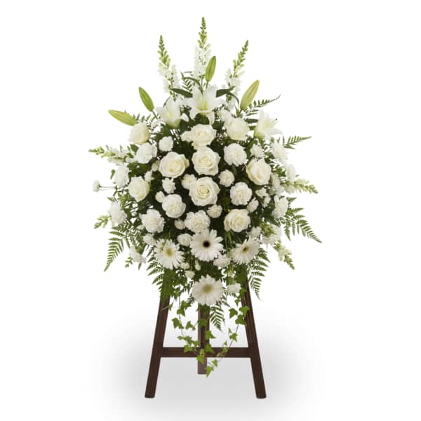 White floral standing spray on a wooden easel