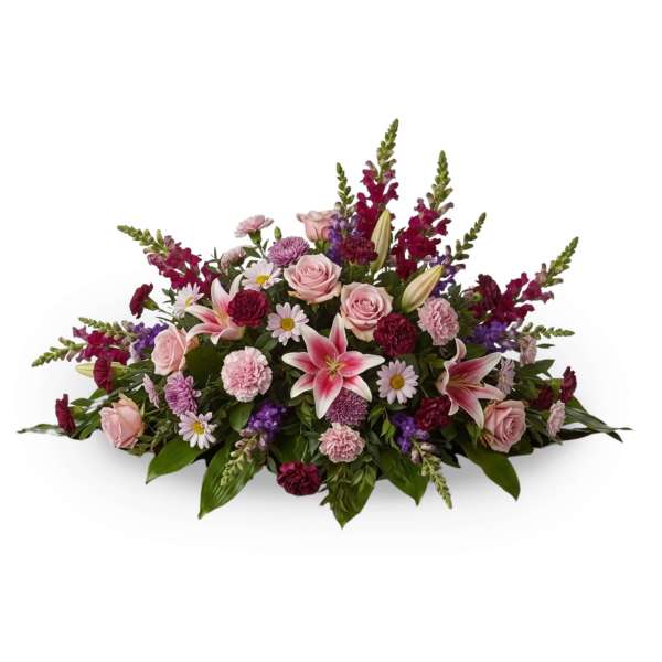 Low floral arrangement with pink roses, lilies, and purple blooms
