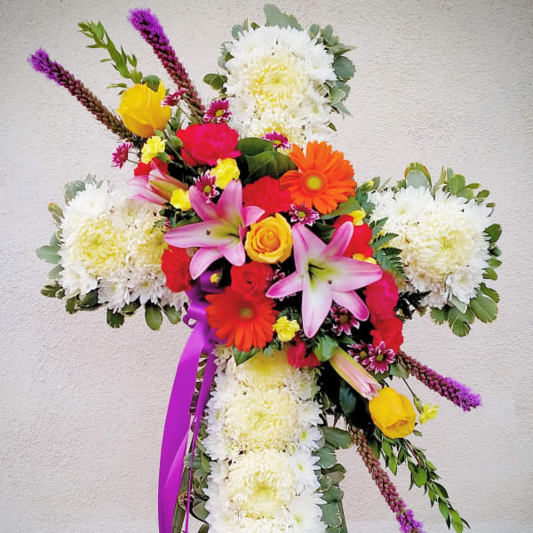 Cross-shaped floral tribute with white chrysanthemums and bright mixed blooms