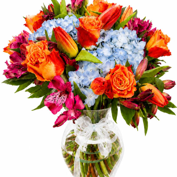 Bright mixed bouquet in a clear glass vase with a white ribbon bow