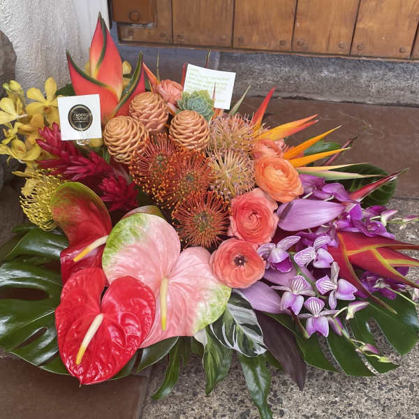 Tropical bouquet with anthuriums, orchids, and orange blooms