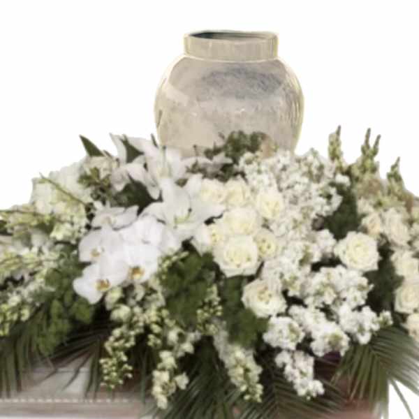 White floral arrangement with orchids and roses around a vase