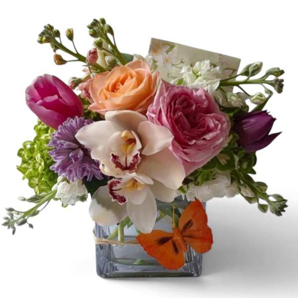 Mixed bouquet in a square glass vase with roses, orchids, and tulips