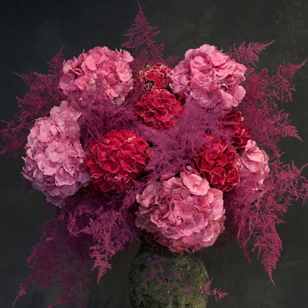 Pink and red hydrangea bouquet in a dark vase