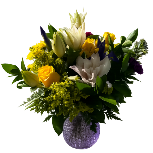 Mixed bouquet of yellow, white, and purple flowers in a textured vase