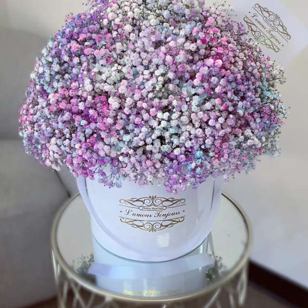 Large pastel bouquet of tiny pink, purple, blue, and white flowers in a white box