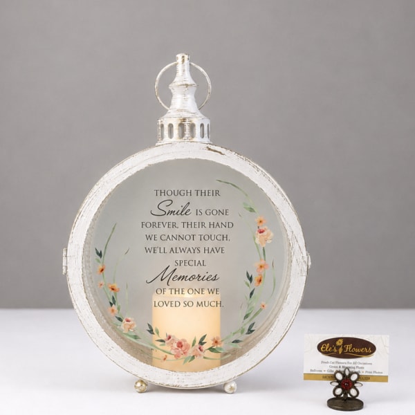 Round white memorial lantern with a candle and floral wreath design