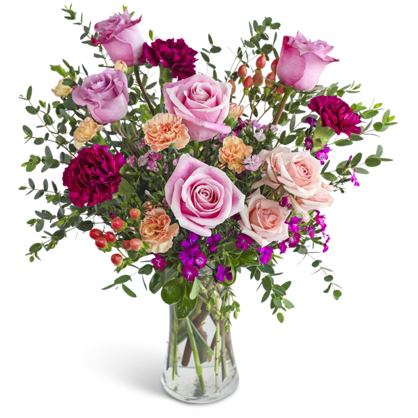 Tall glass vase of pink roses, peach carnations, and dark magenta blooms with berries.