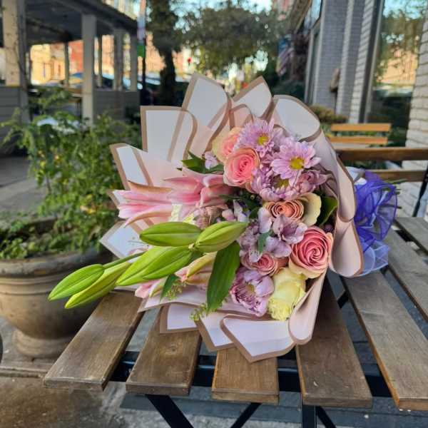 Bouquet of pink and lavender flowers with lily buds wrapped in paper