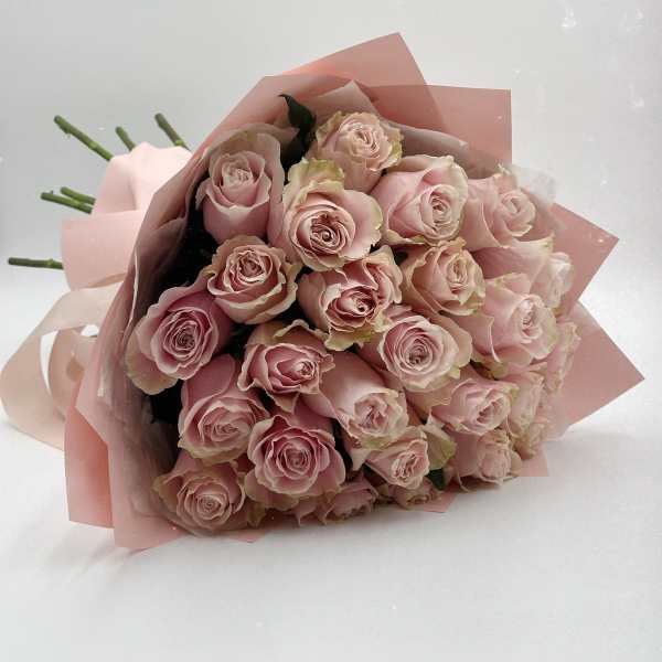 Bouquet of pale pink roses wrapped in pink paper