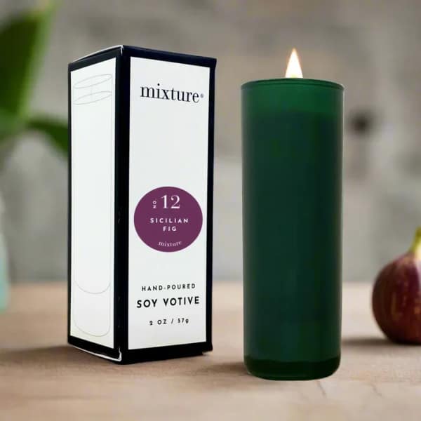 Green votive candle beside its box on a tabletop
