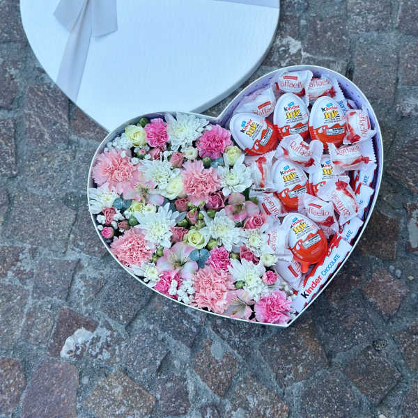 Heart-shaped gift box with pink flowers and chocolates