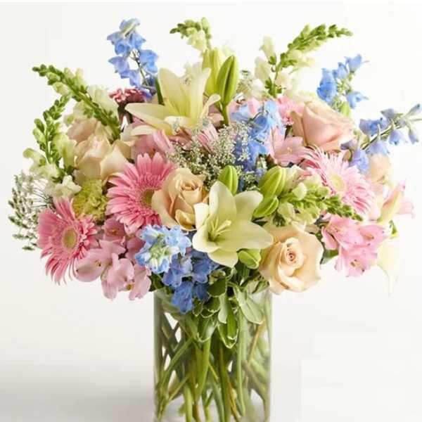 Mixed bouquet of pastel flowers in a clear glass vase