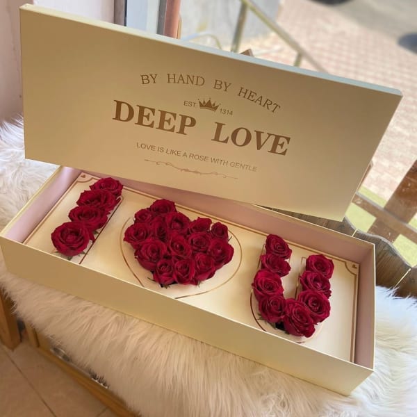 Boxed red rose arrangement spelling "I LOVE U"