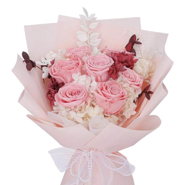 Pink rose bouquet wrapped in pale pink paper with a white ribbon