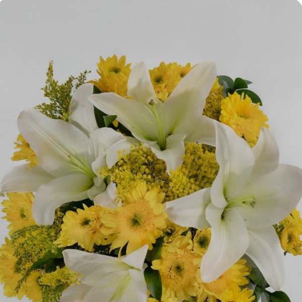 White lilies and yellow daisies in a round bouquet