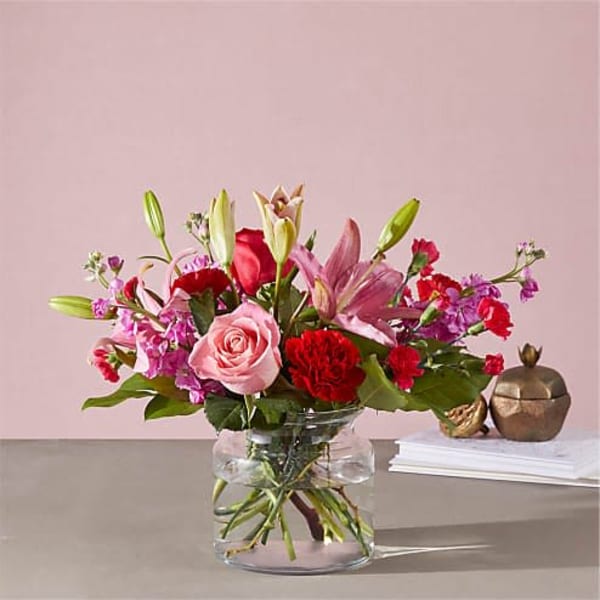 Pink and red mixed flower bouquet in a clear glass vase