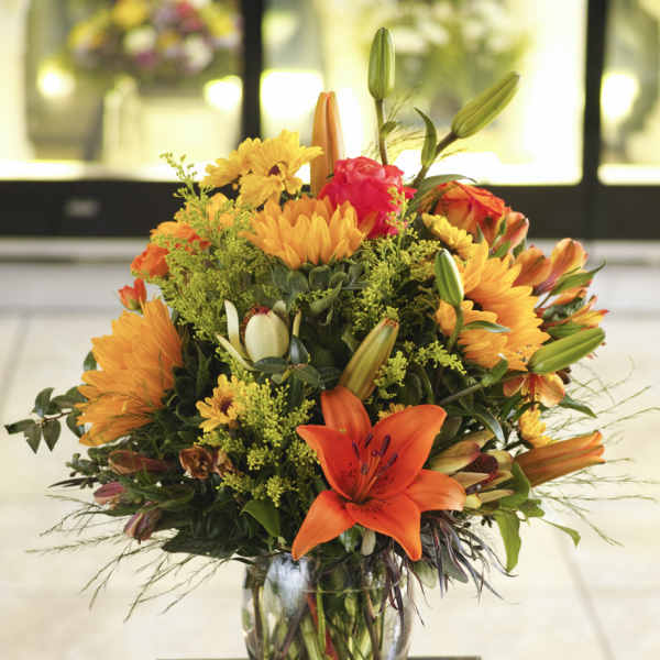 Orange and yellow mixed bouquet in a clear glass vase