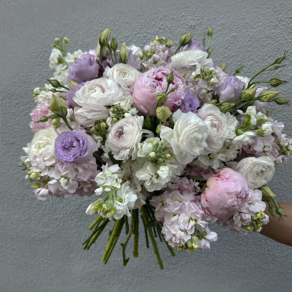 Handheld bouquet of white, pink, and lavender flowers