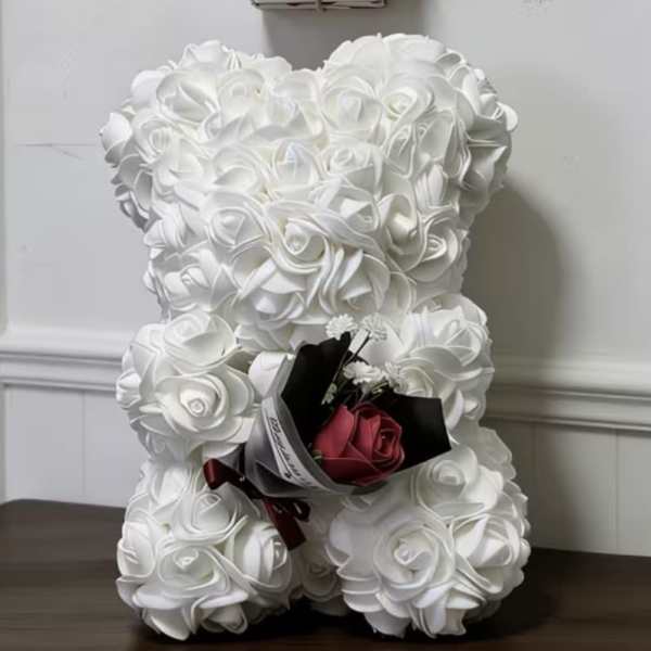 White teddy bear with a small rose bouquet and a "happy mother day" sign