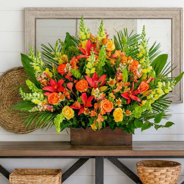Bright tropical flower arrangement in a wooden box on a table