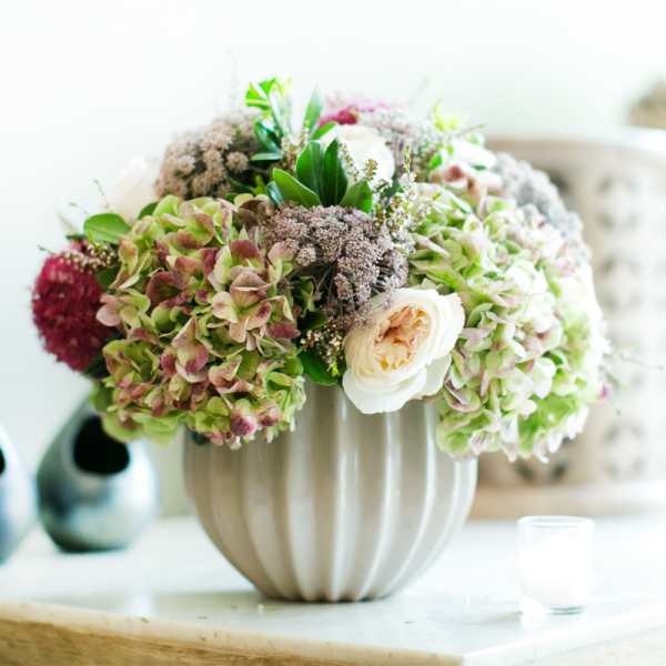 Bouquet of hydrangeas and cream roses in a ribbed vase