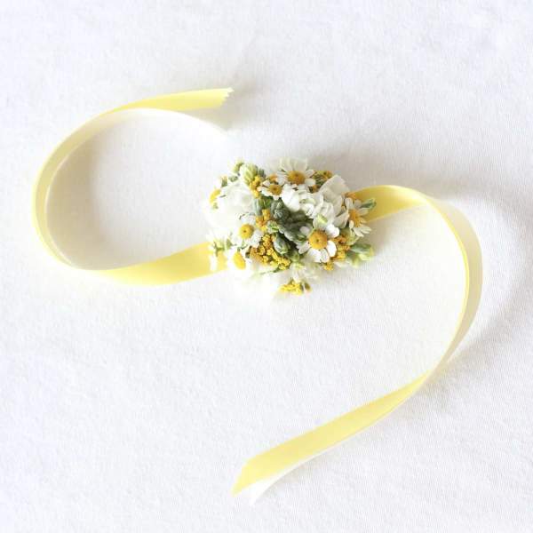 Small floral wrist corsage with white daisies and yellow ribbon
