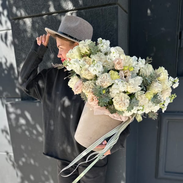 Large bouquet of white and blush flowers in a beige hatbox