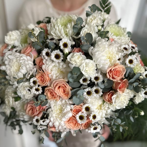 Bouquet of white and peach flowers with eucalyptus greenery