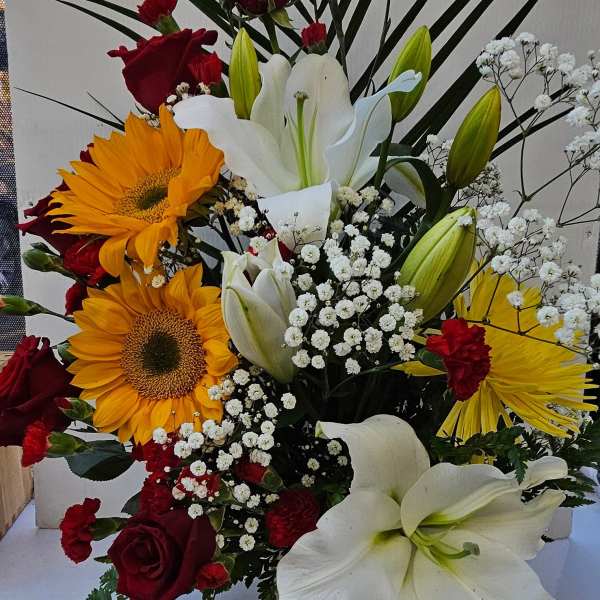 Mixed bouquet with red roses, white lilies, and yellow sunflowers