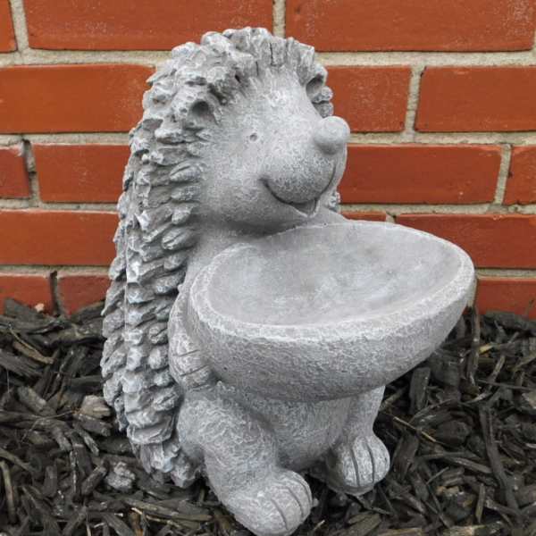 Stone hedgehog garden statue holding a shallow bowl