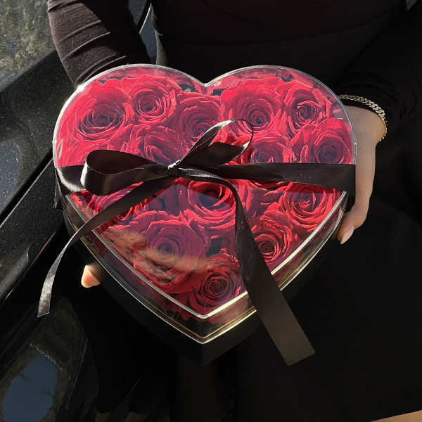 Heart-shaped box of red roses tied with a black ribbon