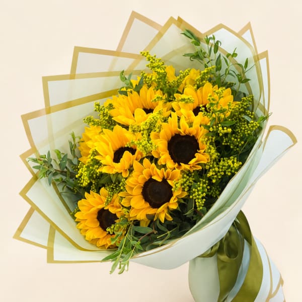 Bouquet of yellow sunflowers wrapped in pale green paper