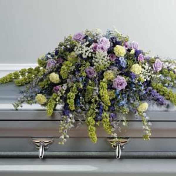 Large floral spray on a casket with purple and yellow flowers