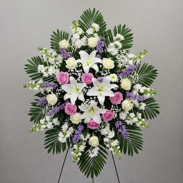 Standing floral spray with white lilies, roses, and purple accents
