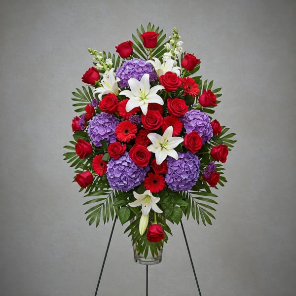 Standing floral spray with red roses, purple hydrangeas, and white lilies