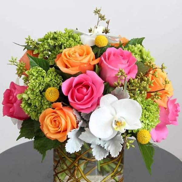 Colorful bouquet of roses and orchids in a glass vase