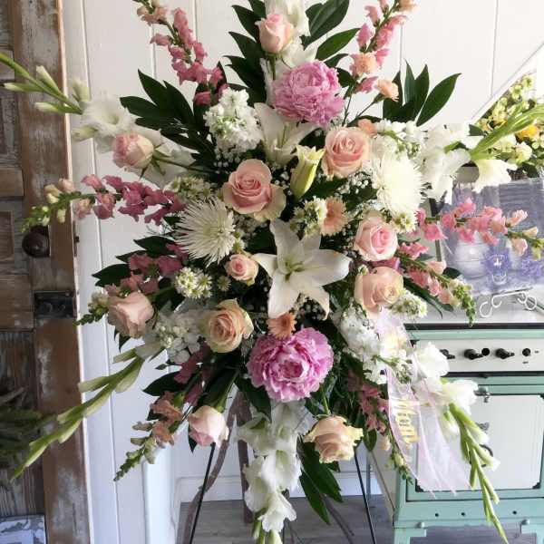 Tall pastel floral standing spray with pink roses and white lilies