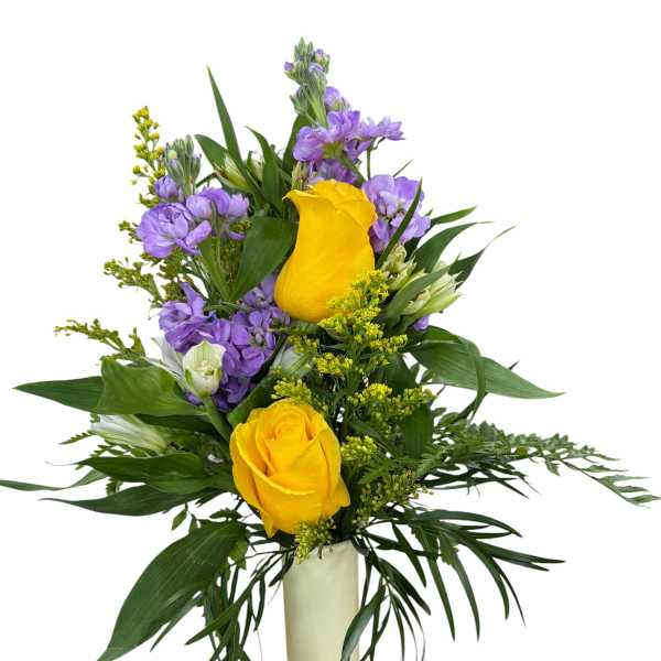 Yellow roses and purple flowers arranged in a tall white vase