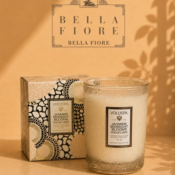 Glass candle in a patterned box beside a matching candle jar