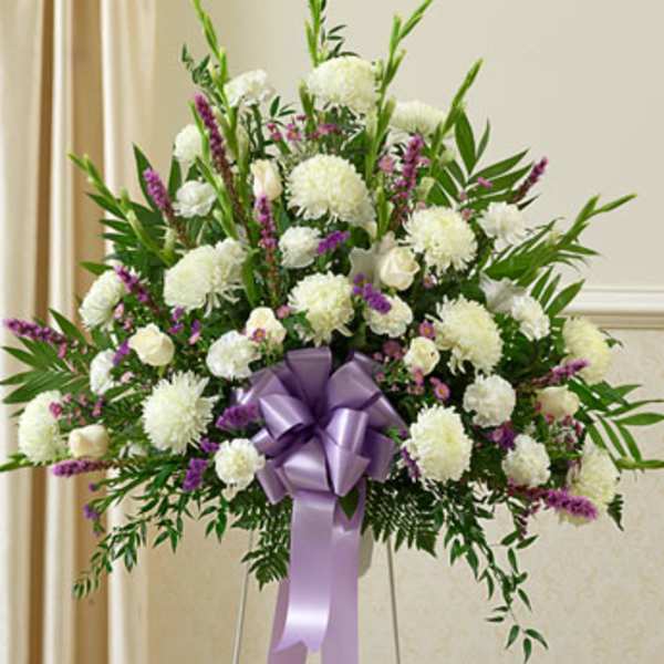 White and purple floral standing spray with a lavender ribbon