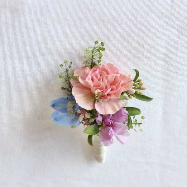 Small pink and blue floral boutonniere with green accents