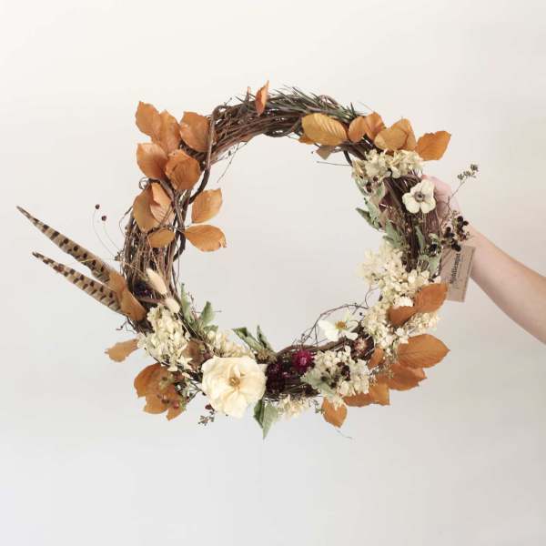 Autumn wreath with cream flowers and orange leaves