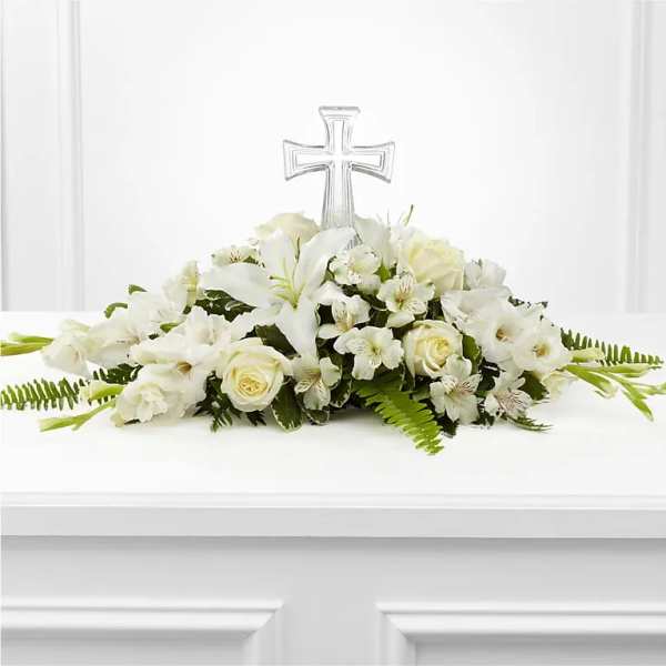 White floral arrangement with a clear cross centerpiece