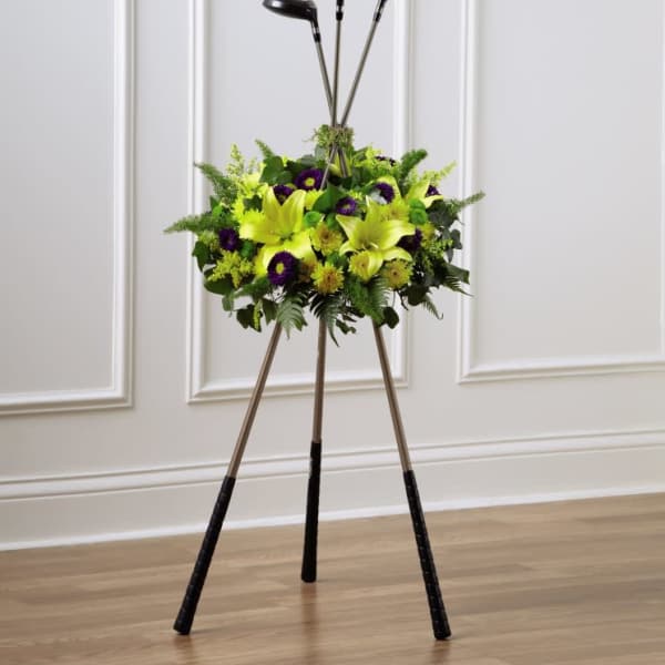 Golf clubs arranged in a floral display with yellow and purple flowers