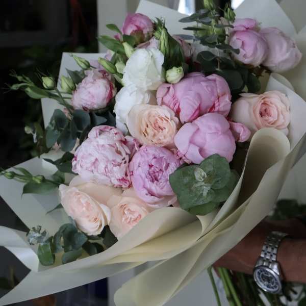 Bouquet of pink and white peonies with eucalyptus in cream wrap