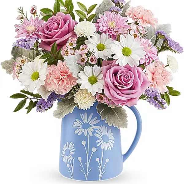 Pink and white flower bouquet in a blue pitcher vase