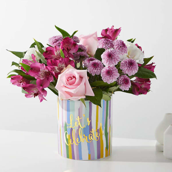 Pink and purple bouquet in a striped "Let's Celebrate" container