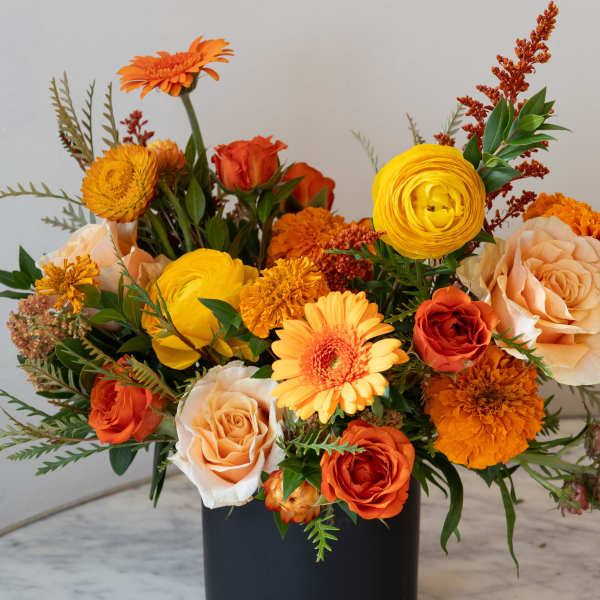 Orange and yellow mixed bouquet in a black vase