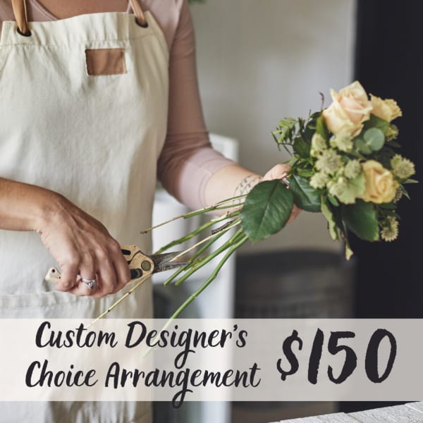 Florist holding a bouquet of pale roses while trimming stems